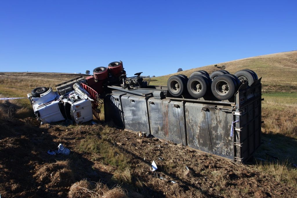 Overturned semi truck in roadside field requires a truck accident attorney in Rancho Cucamonga, California.